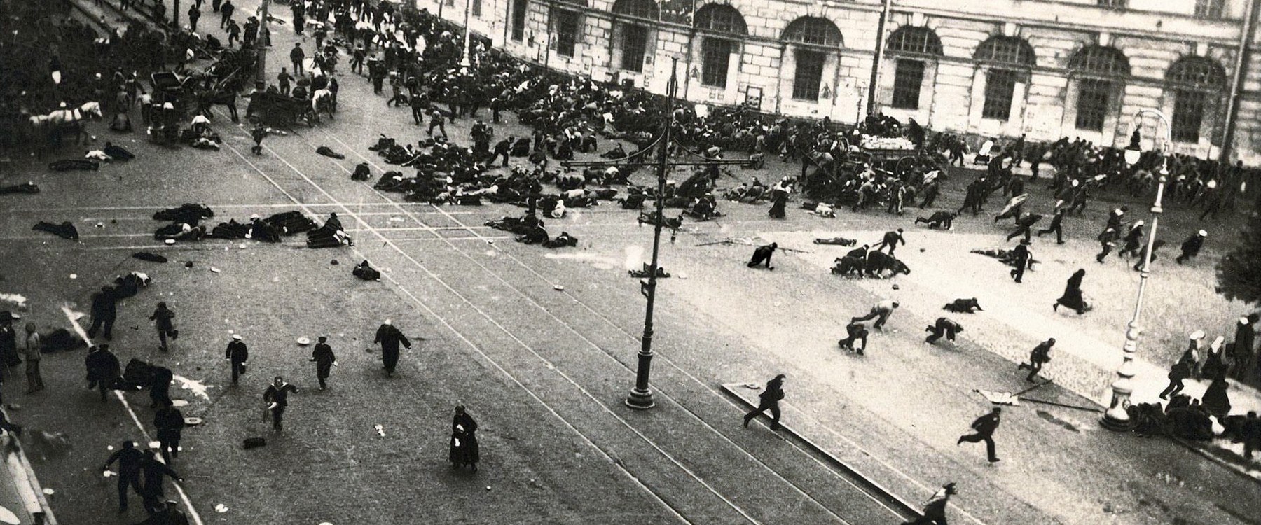 Pohled shora na Něvský prospekt, dav se rozbíhá po střelbě, na dlažbě leží lidé